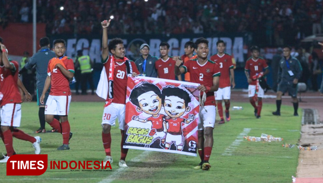 Sikembar Bagus-Bagas saat mengarak spanduk bergambar mereka berdua yang mirip Upin-Ipin keliling Stadion Gelora Delta Sidoarjo, usai kalahkan Malaysia di laga semifinal Piala AFF U-16. (FOTO: Rudi Mulya/TIMES Indonesia)