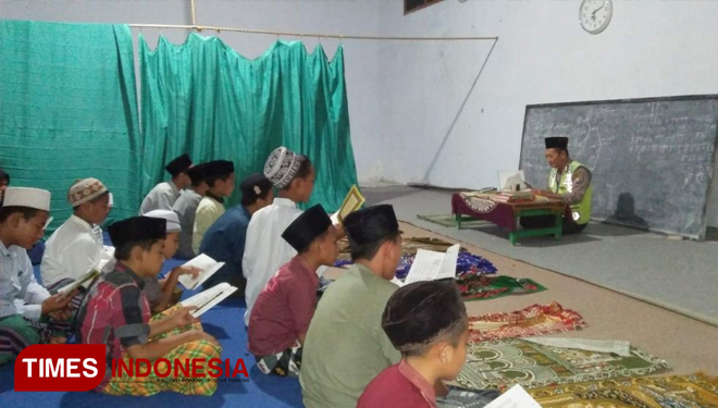 Anggota Polsek Balongpanggang, Aiptu Sunardi sedang mengajar mengaji (FOTO: Humas Polres Gresik for TIMES Indonesia)