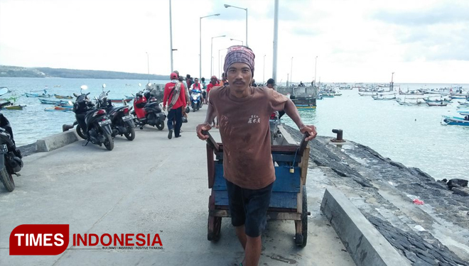 Sumano saat mengisi dua drum air di Pantai Kedonganan, Kecamatan Kuta, Kabupaten Badung, Bali, Sabtu (11/8/2018). (FOTO: Khadafi/TIMES Indonesia)