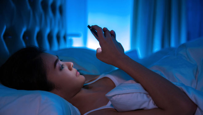 Ilustrasi - bermain ponsel saat akan tidur (FOTO: DailyMail)