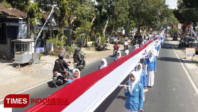 Ribuan Siswa-Siwi MAN Bondowoso dibantu aparat kepolisian dan TNI mengarak kain merah putih dengan panjang 1111 meter. (FOTO: Moh Bahri/TIMES Indonesia)