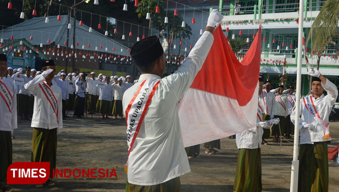 Santri Pondok Pesantren Syaichona Mohammad Cholil Demangan, Bangkalan, mengibarkan bendera Merah Putih ketika upacara kemerdekaan. (FOTO: Doni Heriyanto/TIMES Indonesia)