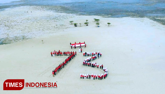 Ratusan pemuda melaksanakan upacara bendera dengan membentuk angka 73 di salah satu destinasi wisata Kota Bontang, Pulau Segajah. (FOTO: Kaltimwow for TIMES Indonesia)