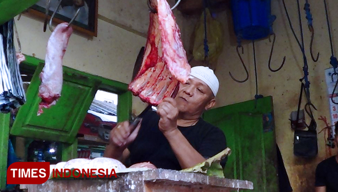 H. Rifa'i ketua paguyuban pedagang daging sapi wilayah Kraksaan, Kabupaten Probolinggo, Jawa Timur, saat melayani pembeli daging sapi di lapaknya. (FOTO: Dicko W/TIMES Indonesia)