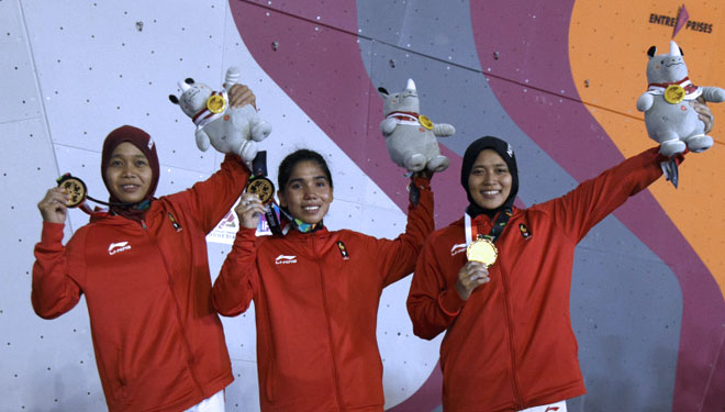 Indonesian rock climbing team Puji Lestari (left) Rajiah Sallsabillah (center) and Aries Susanti Rahayu (right) show a gold medal after winning the women's speed relay final in the 2018 Asian Games (ANTARA PHOTOS / INASGOC / Hendra Nurdiyansyah)