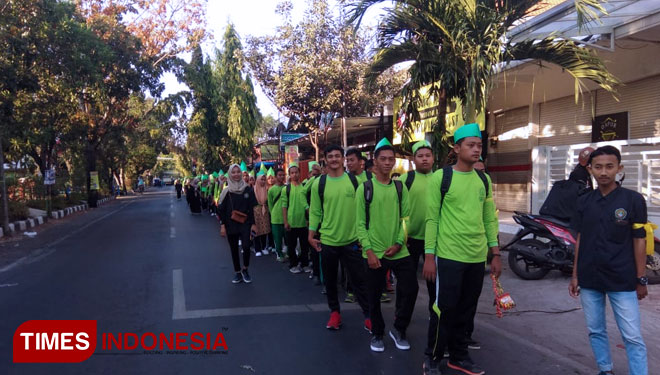 Mahasiswa Baru Unisla membawa sampah plastik yang sudah dipungut di sejumlah titik dalam jalan sehat dalam rangkaian PKKMB Unisla, Minggu, (9/9/2018). (FOTO: Siti Nura/TIMES Indonesia)