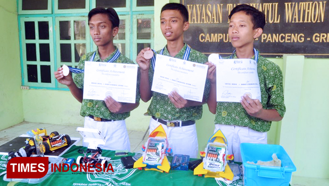 Tiga siswa MTs Tarbiyatul Wathon Kabupaten Gresik memamerkan piagam penghargaan saat menjuarai kontea robot Internasional di Malaysia. (FOTO: Akmal/TIMES Indonesia)