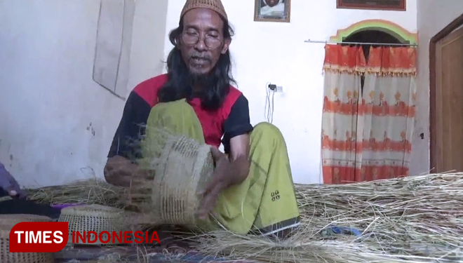 Abdussalam, warga Desa Ngasem Lemahbang, Kecamatan Ngimbang, Kabupaten Lamongan, menunjukkan cara pembuatan kopyah dari rumput otok, Sabtu, (22/9/2018). (FOTO: MFA Rohmatillah/TIMES Indonesia)