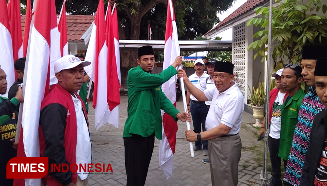 Penyerahan Bendera Merah Putih dari Ketua PC Ansor Sumbawa, Syamsul Munir kepada Wakil Bupati Sumbawa, Mahmud Abdullah. (FOTO: PC Ansor Sumbawa for TIMES Indonesia)