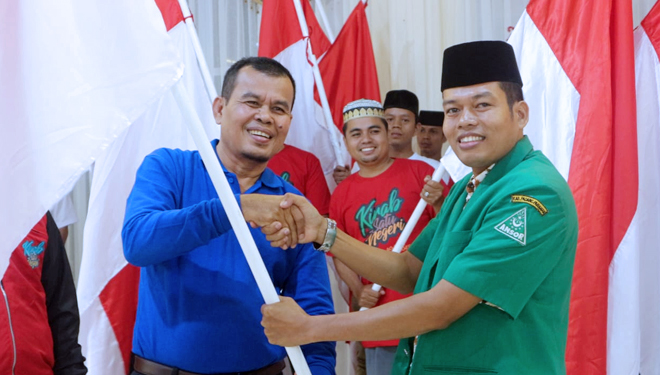 Walikota Pariaman Mukhlis Rahman menerima pataka Bendera Merah Putih Ketua PC Gerakan Pemuda Ansor Padang Pariaman Zeki Aliwardana. (FOTO: Istimewa)