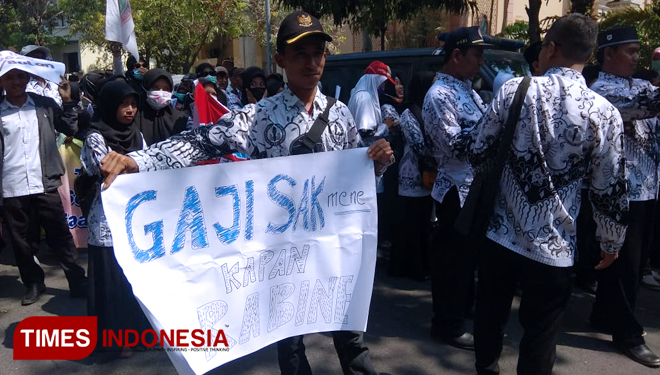 Spanduk bertuliskan curhatan guru honorer, warnai aksi unjuk rasa guru honorer di Lamongan, Rabu, (26/9/2018). (FOTO: MFA Rohmatillah/TIMES Indonesia)