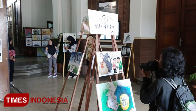 Seorang fotografer mengabadikan momen di pameran anti korupsi di Balai Kota Malang. (FOTO: Imadudin Muhammad/TIMES Indonesia)