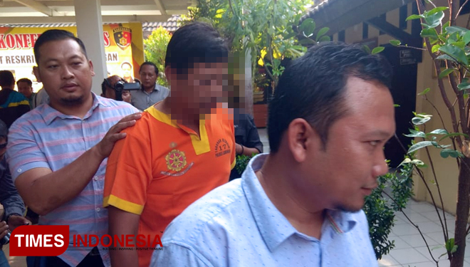 Terduga kasus penipuan CPNS, SN saat dibawa petugas Kepolisian Resort (Polres) Lamongan, di Mapolres Lamongan, Rabu (12/10/2018). (FOTO: MFA Rohmatillah/TIMES Indonesia)