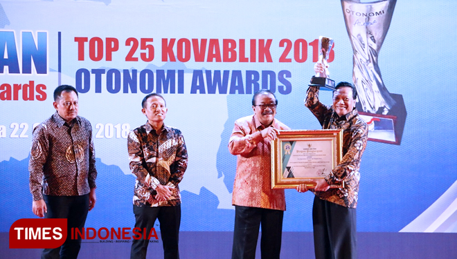 Bupati Gresik Sambari Halim Radianto saat menerima penghargaan yang diberikan Gubernur Jawa Timur Soekarwo. (FOTO: Humas Pemkab Gresik for TIMES Indonesia) 