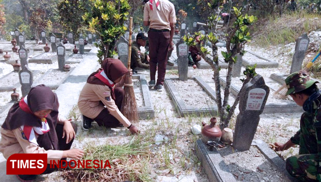 Pramuka Saka Wirakartika membersihkan taman makan pahlawan di lokasi TMMD Kodim Sleman Desa Balecatur Gamping Sleman. (FOTO: AJP TIMES Indonesia)