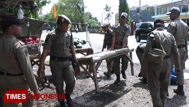 Sejumlah petugas Satpol PP Kabupaten Probolinggo, Jawa Timur, menertibkan lapak milik pedagang buah tak berizin di pinggir jalan raya Kraksaan.(FOTO: Dicko W/TIMES Indonesia)