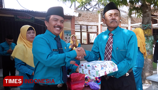 Guru Mansur menerima kado kenang-kenangan dari DR. R. Chusnu Yuli Setyo, Kepala SMPN 1 Karanggeneng, Sabtu, (10/11/2018). (FOTO: MFA Rohmatillah/TIMES Indonesia)