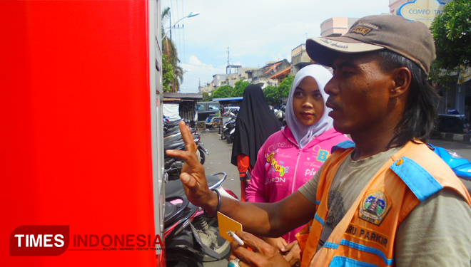 Warga saat dibantu juru parkir saat membayar parkir di E-Parkir (FOTO: Akmal/TIMES Indonesia). 