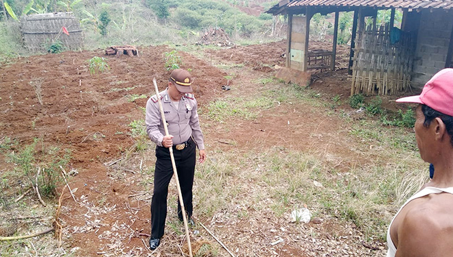 Petugas Polsek Pulung dan warga menandai retakan yang terjadi di sekitar lokasi tanah longsor Banaran. (FOTO: Istimewa)