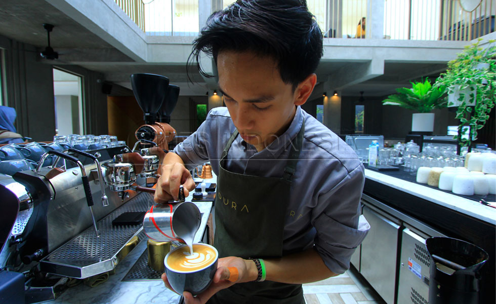 Barista sedang membuat latte art kopi yang bisa di lihat langsung oleh pengunjung Oura. (Foto : Tria Adha/TIMES Indonesia).