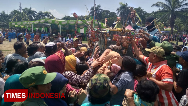 Warga Kota Madiun berebut gunungan di alun-alun saat puncak grebeg maulid. (FOTO: Pamula Yohar C/TIMES Indonesia)