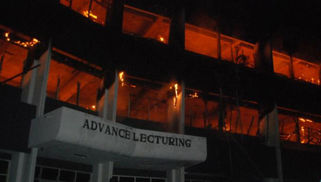 Petugas pemadam kebakaran berusaha memadamkan api yang membakar gedung FKIP Universitas Darul Ulum (Undar) Jombang, Jawa Timur, Senin (3/12/2018). (Foto: Antara Jatim)