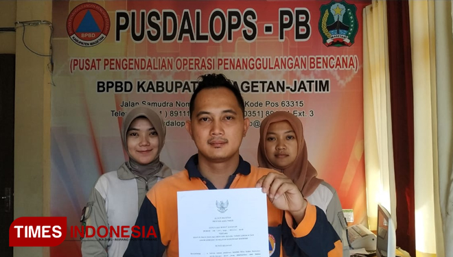Kasi Kedaruratan dan Logistik BPBD Magetan, Feri Yoga Saputra (tengah), menunjukkan Surat Keputusan (SK) Bupati Magetan tentang status siaga darurat bencana banjir, tanah longsor dan angin kencang Magetan. (FOTO: MK Adinugroho/TIMES Indonesia)