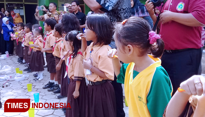 Puluhan siswa SDN Mengen 1, Desa Mengen Kecamatan Tamanan, Kabupaten Bondowoso saat mengikuti praktik sikat gigi dengan benar. (FOTO: Moh Bahri/TIMES Indonesia) 