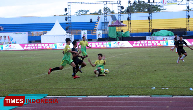 Pemain Bontang (hitam-hitam) dikawal ketat pemain Paser (hijau - kuning) pada laga lanjutan penyisihan grup B sepak bola Porprov ke VI tahun 2018. (Foto: Yuli Pktv for TIMES Indonesia)