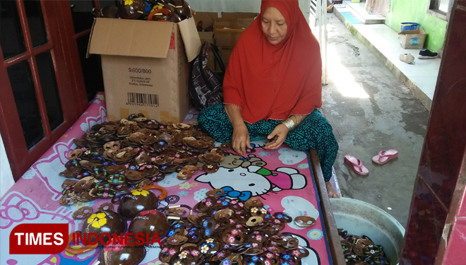 Ibu Haji Tahira saat membersihkan Gasper dan tempat sabun dari bahan batok kelapa. Selasa (11/12/2018). (FOTO: Khadafi/TIMES Indonesia).