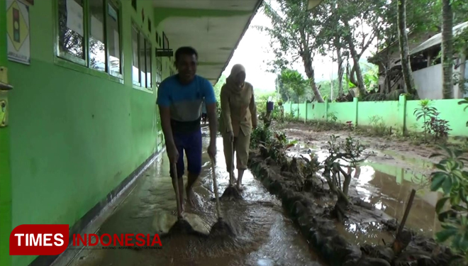 Sejumlah guru membersihkan sisa banjir bandang. (FOTO: Nisun for TIMES Indonesia)