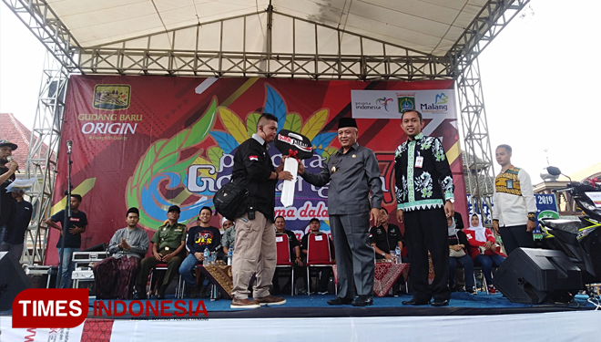 Plt Bupati Malang Drs HM Sanusi MM saat memberikan secara simbolis hadiah utama berupa sepeda motor kepada Ketua Panitia Festival Pesona Gondanglegi, Sugeng Harianto. (FOTO: Binar Gumilang/TIMES Indonesia)