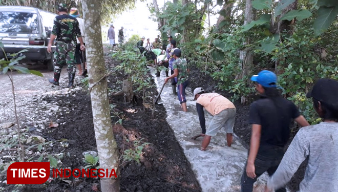 Personel Koramil 0824/23 Wuluhan saat melaksanakan Pembersihan selokan bersama warga masyarakat. (FOTO: AJP/TIMES Indonesia)