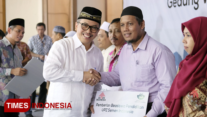 Direktur SDM dan Hukum Semen Indonesia Agung Yunanto (kiri berbaju putih) secara simbolis menyerahkan beasiswa kepada perwakilan siswa (FOTO: Akmal/TIMES Indonesia)
