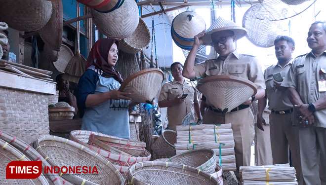 Bupati Anas tengah mencoba kerajinan bambu yang dijual oleh pedagang (Foto: Roghib Mabrur/TIMES Indonesia)