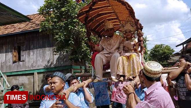 Sang mempelai sedang digotong dan diarak mengelilingi Kampung dalam Tradisi Be Juli. (FOTO: Bambang For TIMES Indonesia)