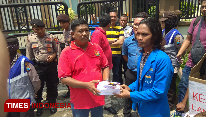 Fahmi Fikri, Ketua PC PMII Lamongan, menyerahkan cinderamata kepada petugas Kejari Lamongan, Jum'at (18/1/2019). (FOTO: MFA Rohmatillah/TIMES Indonesia)