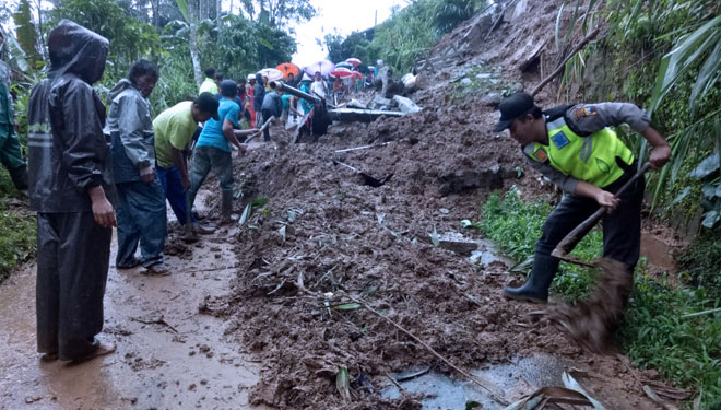 Anggota Polsek dan Koramil Karangjambu, BPBD dan masyarakat setempat melakukan pembersihan jalan dari material tanah longsor. (FOTO: Istimewa)