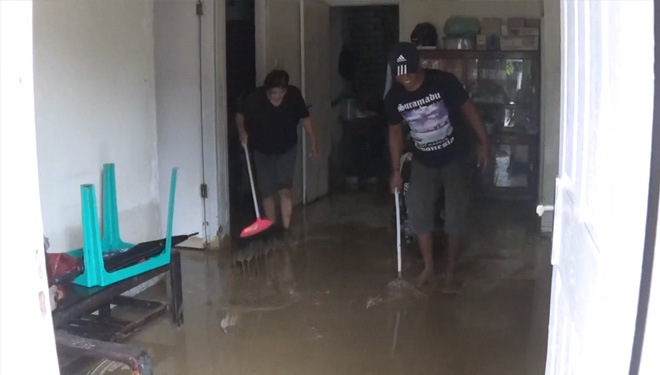 Warga perumahan Graha Indah Paciran, Lamongan membersihkan lumpur sisa banjir, Selasa (29/1/2019). (FOTO: Istimewa)