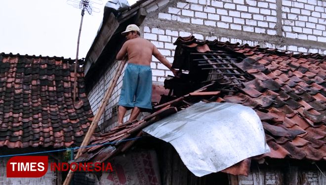 Warga memperbaiki bangunan rumahnya yang rusak setelah hujan angin, Selasa (05/02/2019) (FOTO: Achmad Choirudin/TIMESIndonesia)
