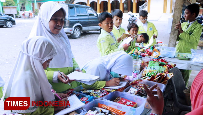 Salah satu siswi saat mewawancari penjual makanan di kantin sekolah (FOTO: Akmal/TIMES Indonesia)