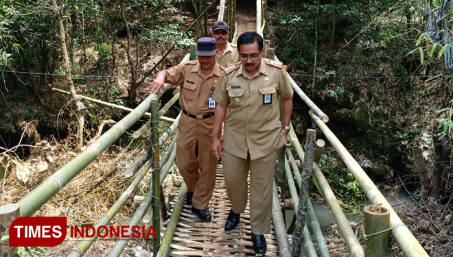 Camat Pagak Hari Krispiyanto saat mencoba jembatan darurat dari bambu hasil swadaya masyarakat beserta desa. (Foto : Binar Gumilang / TIMES Indonesia)