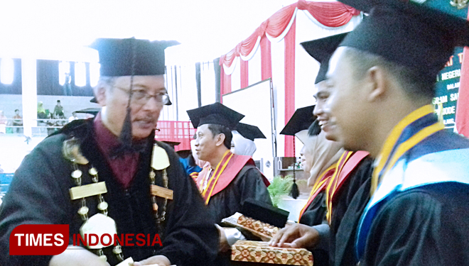 The Rector of UIN Malang is giving the award to one of the best graduates. (PHOTO: Nur Aini/TIMES Indonesia)