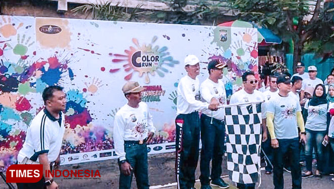 Kapolres Magetan dan Bupati Magetan memegang bendera start, saat akan memberangkatkan peserta Colour Run Millenial Road Safety Festival di depan Stadion Yosonegoro Magetan. (FOTO: M Kilat Adinugroho/TIMES Indonesia)