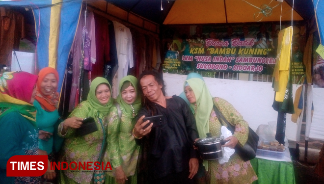 Sejumlah anggota Muslimat NU saat foto selfie bersama Cak Sodiq di stand Pasar Rakyat Muslimat NU Jatim. (FOTO: Rudi/TIMES Indonesia)