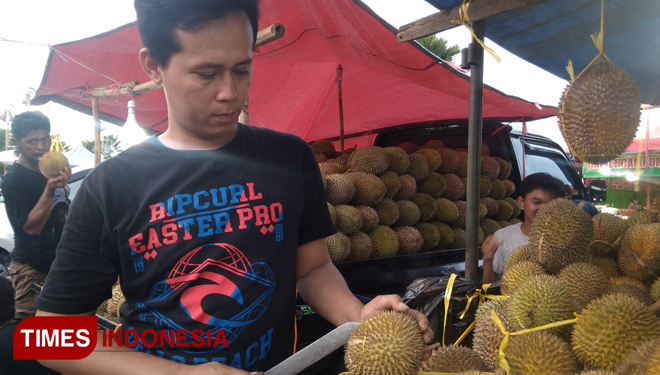 Pedagang durian saat melayani pembeli di event mendem duren Gresik. (FOTO: Akmal/TIMES Indonesia)