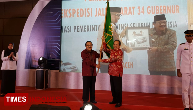 Soekarwo (kiri) memberikan pataka APPSI pada ketum APPSI baru Longki Djanggola. (FOTO: Kiagus Firdaus/TIMES Indonesia)