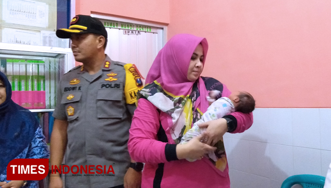 Kapolres Probolinggo AKBP Eddwi Kurniyanto, bersama istri saat menggendong bayi yang ditelantarkan ibunya.(FOTO: Dicko W/ TIMES Indonesia)