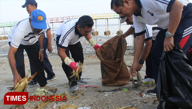 Kapolres Lamongan, AKBP Feby DP Hutagalung memungut sampah di Pantai Kutang, Kecamatan Brondong Lamongan, Jum'at (22/2/2019). (FOTO: Istimewa/TIMES Indonesia)
