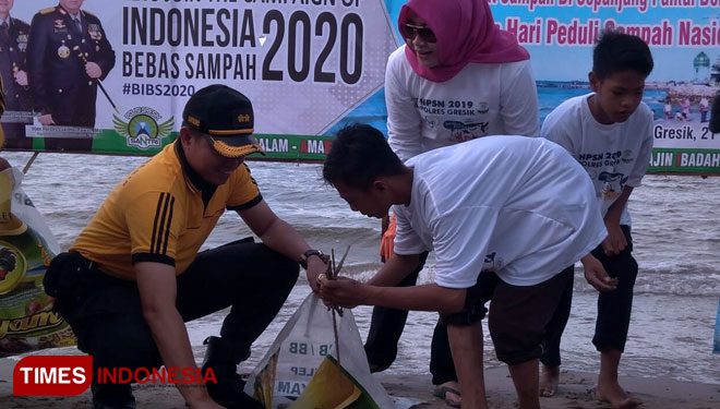 Kapolres Gresik AKBP Wahyu Sri Bintoro saat memunguti sampah (Foto: Akmal/TIMES Indonesia)